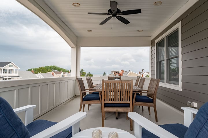 enclosed deck with blue outdoor furniture and ceiling fan