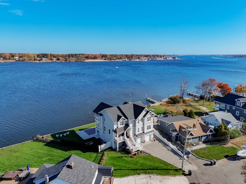 Aerial view of a GTG Builders custom home in Brick, NJ, with expansive water views, dock access, and a spacious lot