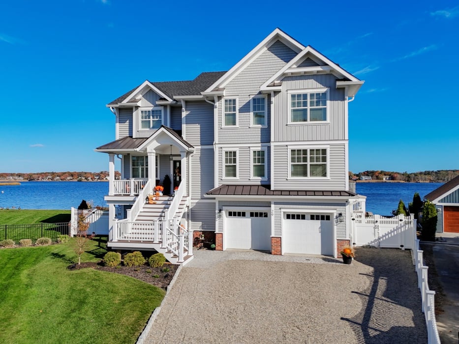 further back view of thwo story custom home with expansive stairs, double garage, long garage on metedeconk river