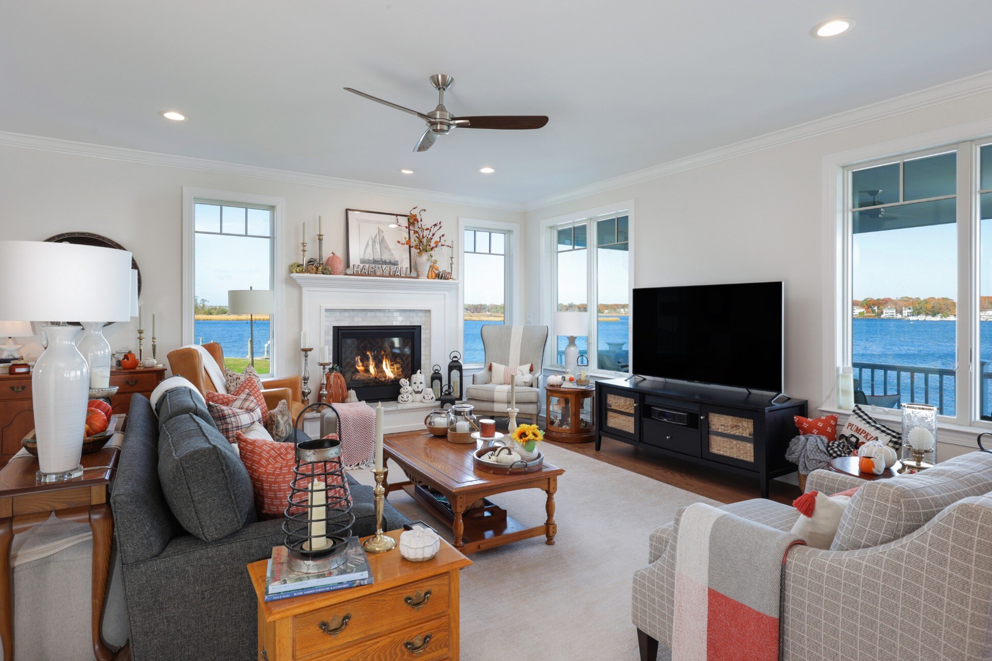 Cozy living room with a fireplace and waterfront views in a custom home by GTG Builders in Brick, NJ, featuring comfortable seating and seasonal decor