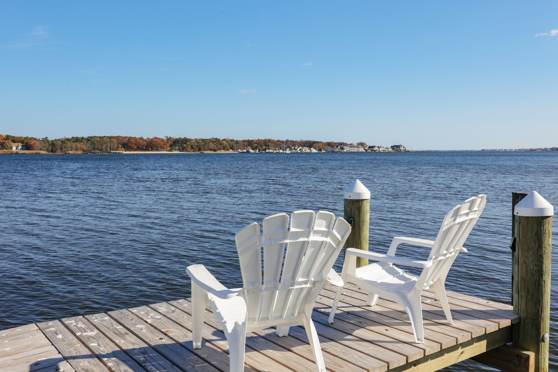 Dockside seating area with Adirondack chairs offering a relaxing waterfront view, part of a custom home by GTG Builders in Brick, NJ