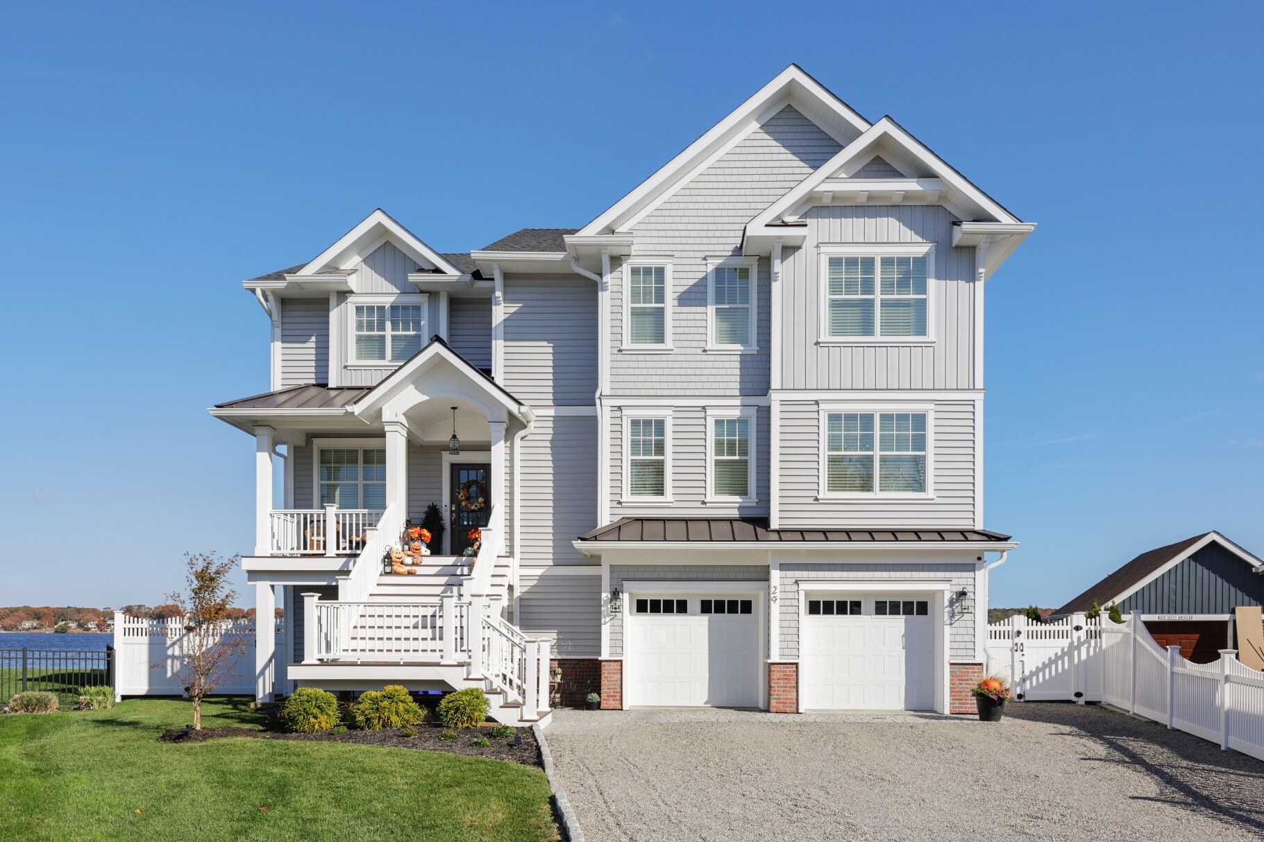 Elegant custom-built home by GTG Builders in Brick, NJ, featuring multiple floors, large windows, and a well-manicured lawn