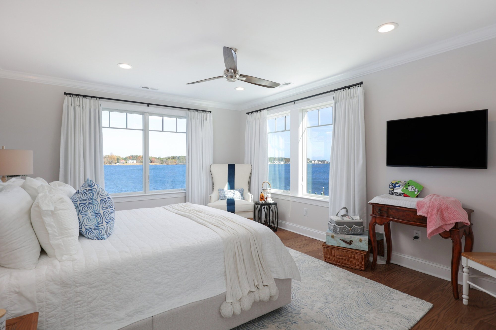 Guest bedroom with waterfront views, upholstered headboard, and cozy decor in a custom home by GTG Builders in Brick, NJ