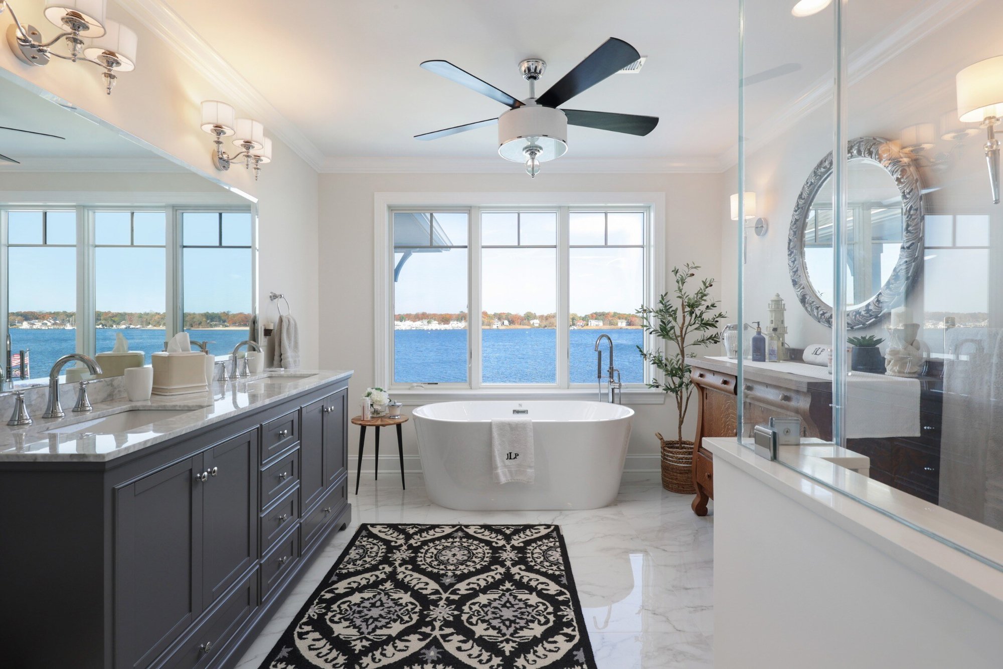 Luxurious bathroom with freestanding tub, large vanity, and panoramic waterfront view, designed by GTG Builders in Brick, NJ