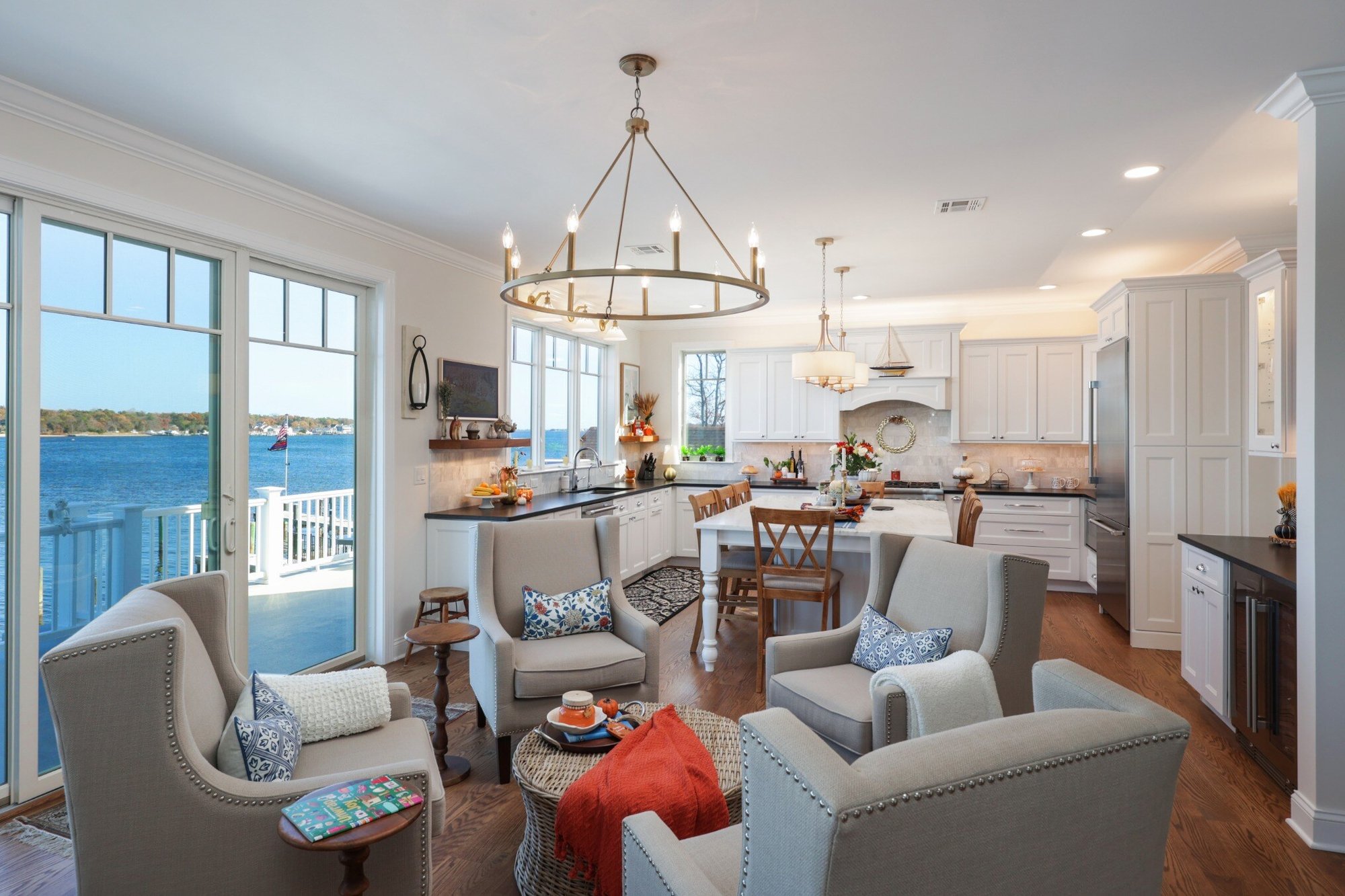 Open-concept kitchen and sitting area with waterfront views in a custom home by GTG Builders in Brick, NJ, showcasing elegant lighting and comfortable seating