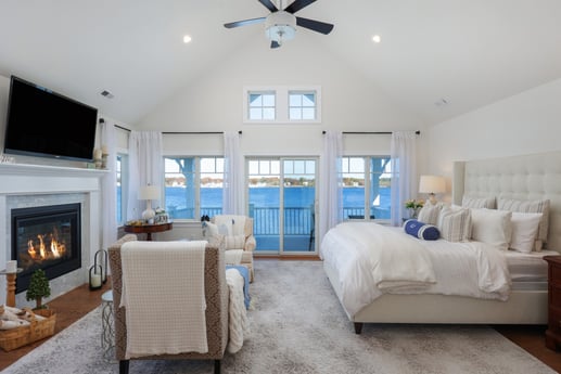 Spacious master bedroom with vaulted ceiling, fireplace, seating area, and waterfront views in a custom home by GTG Builders in Brick, NJ-1