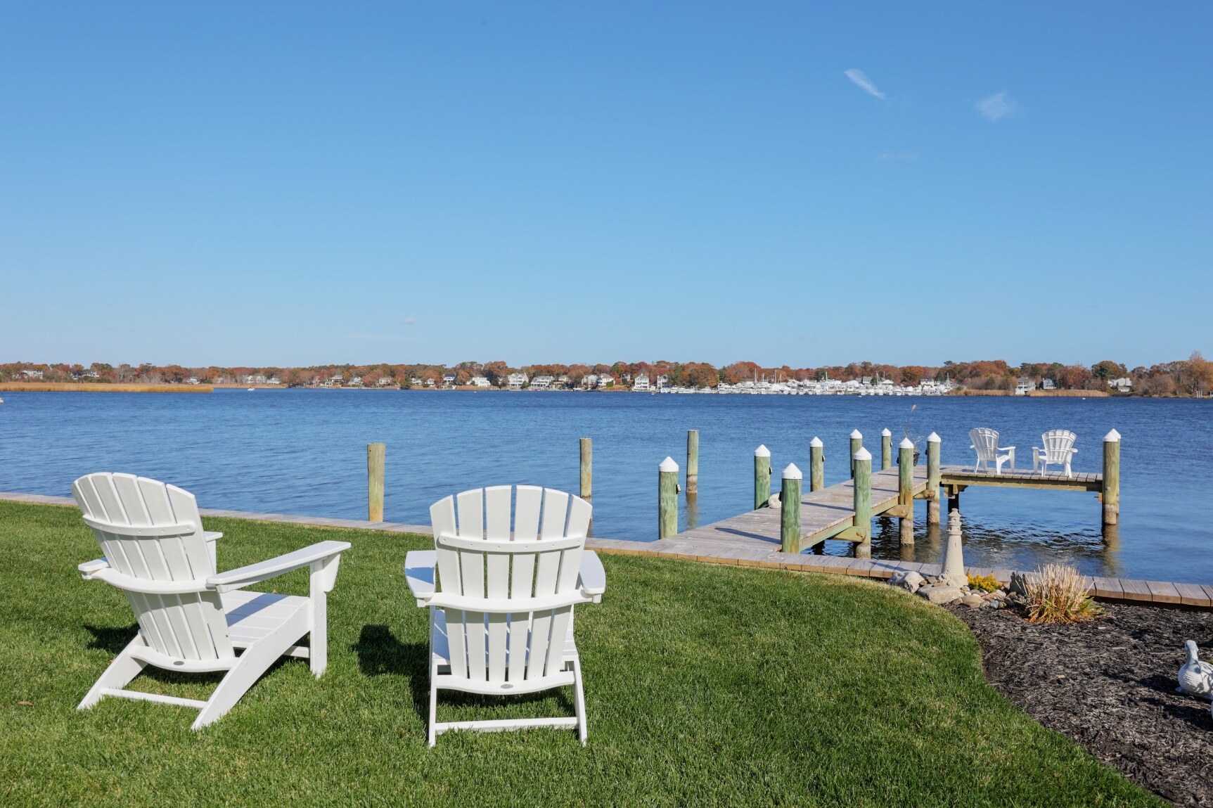 Waterfront backyard and dock area of a custom home by GTG Builders in Brick, NJ, with ample outdoor seating for relaxation and gatherings