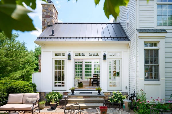 Exterior of 4-season room addition open doors to home by GTG Builders in Central, NJ