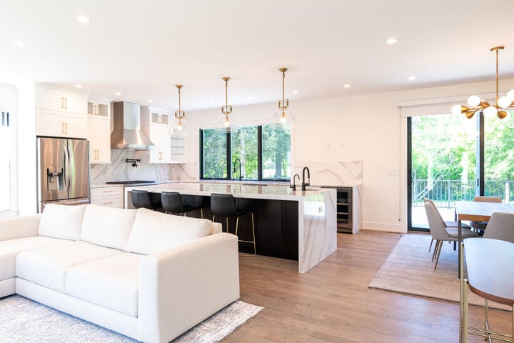 living area and kitchen with white couch and cabinets in custom home by GTG Builders in Central New Jersey
