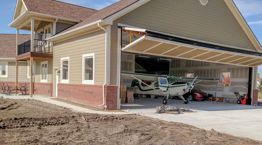 beige house with large garage built for housing small airplanes - photo from Pinterest