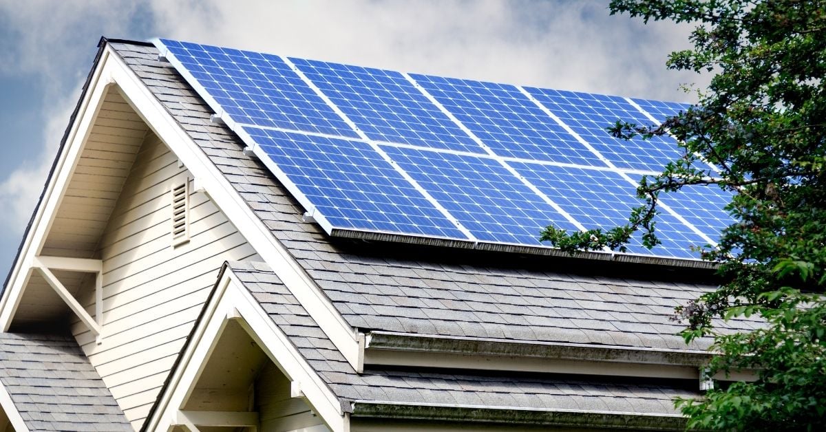 gray roof with solar panels attached and cloudy sky