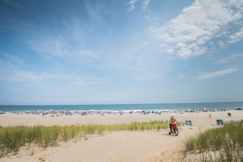 person rolling cooler on beach sand in LBI - photo by New Jersey Monthly