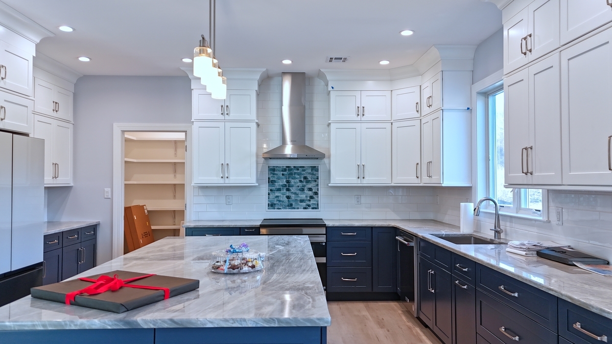 Bright modern kitchen with white upper cabinets and navy blue lower cabinets in a net-zero custom home in Bloomsbury, NJ by GTG Builders