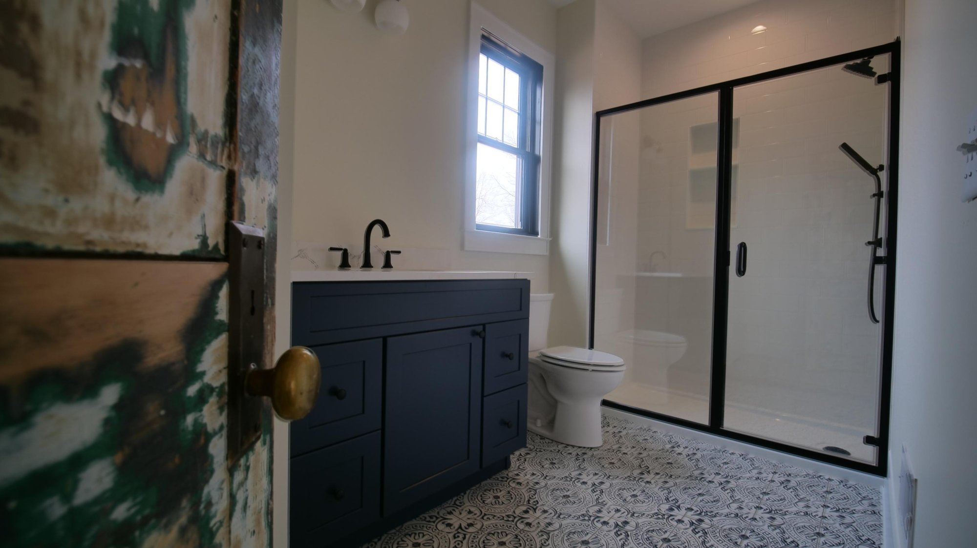 primary bathroom blue and white tile and blue vanity