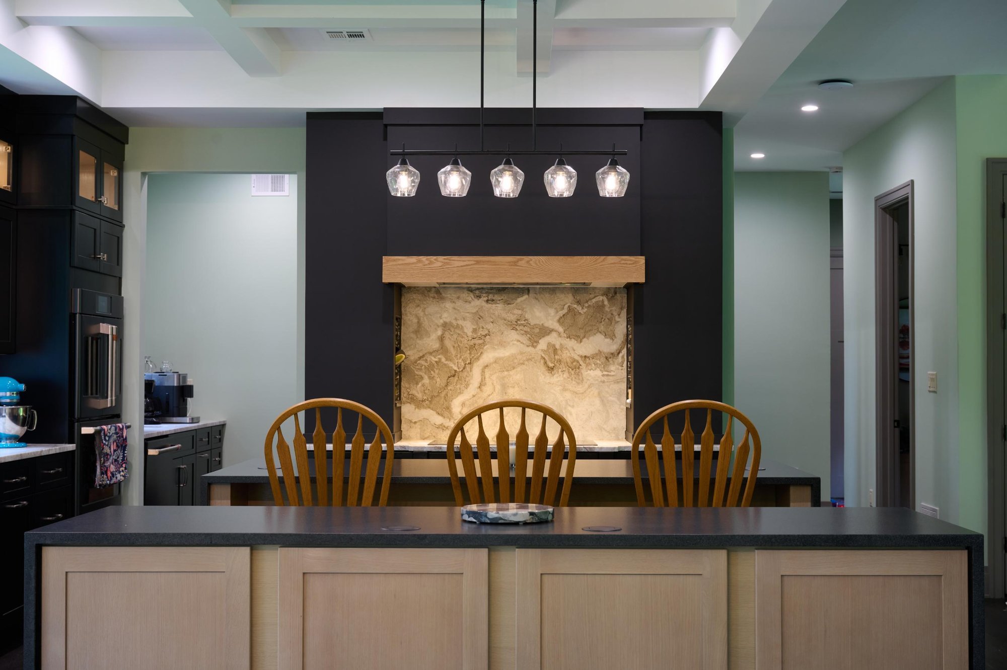 Kitchen Island with with Custom Backsplash in Tan Tile with Marble Pattern and Pendant Lights by GTG Builders in Delaware Township