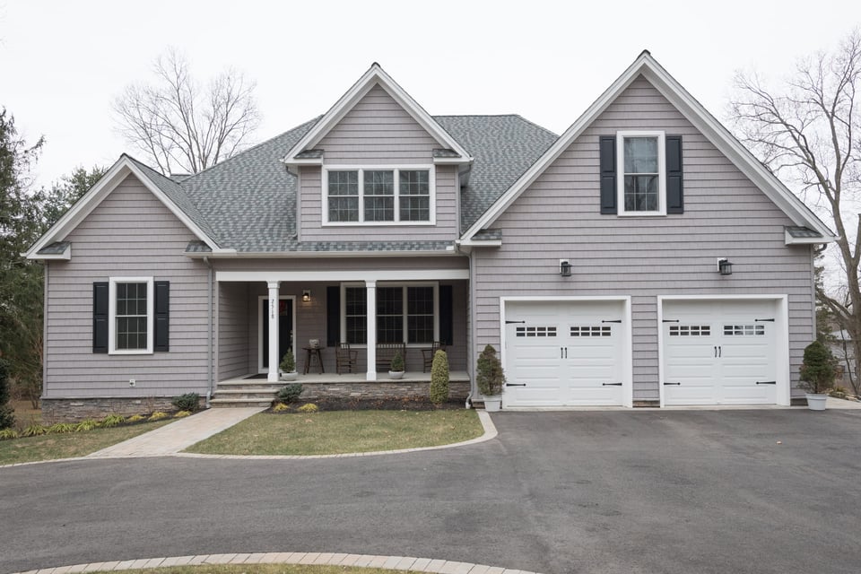 grey custom home with 2 white garages by GTG custom home builders in new jersey