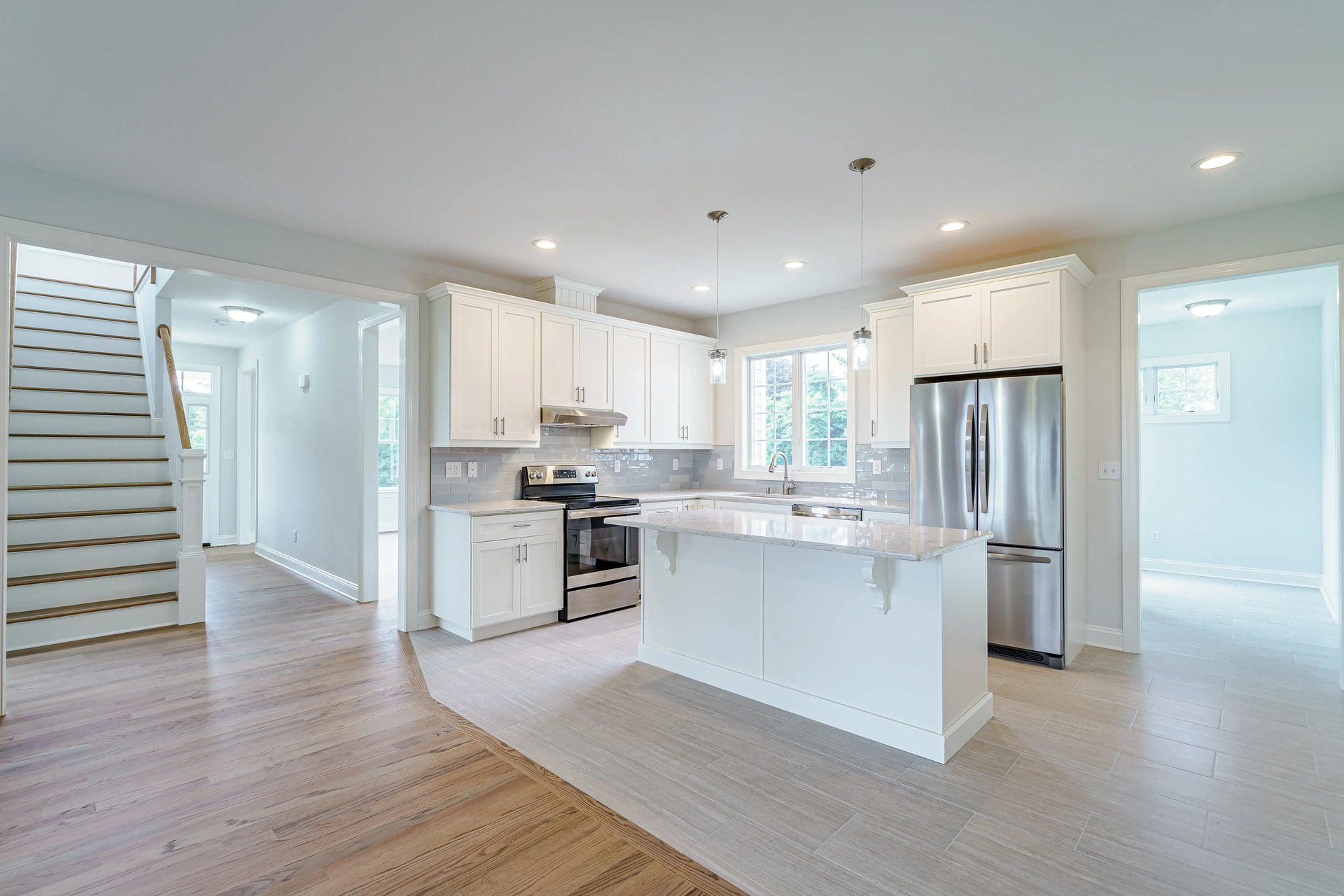 kitchen inside custom home with white cabinets and island by gtg builders in central new jersey