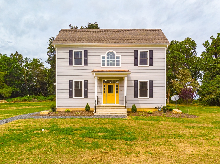 exterior of custom home with yellow door in central new jersey by gtg builders