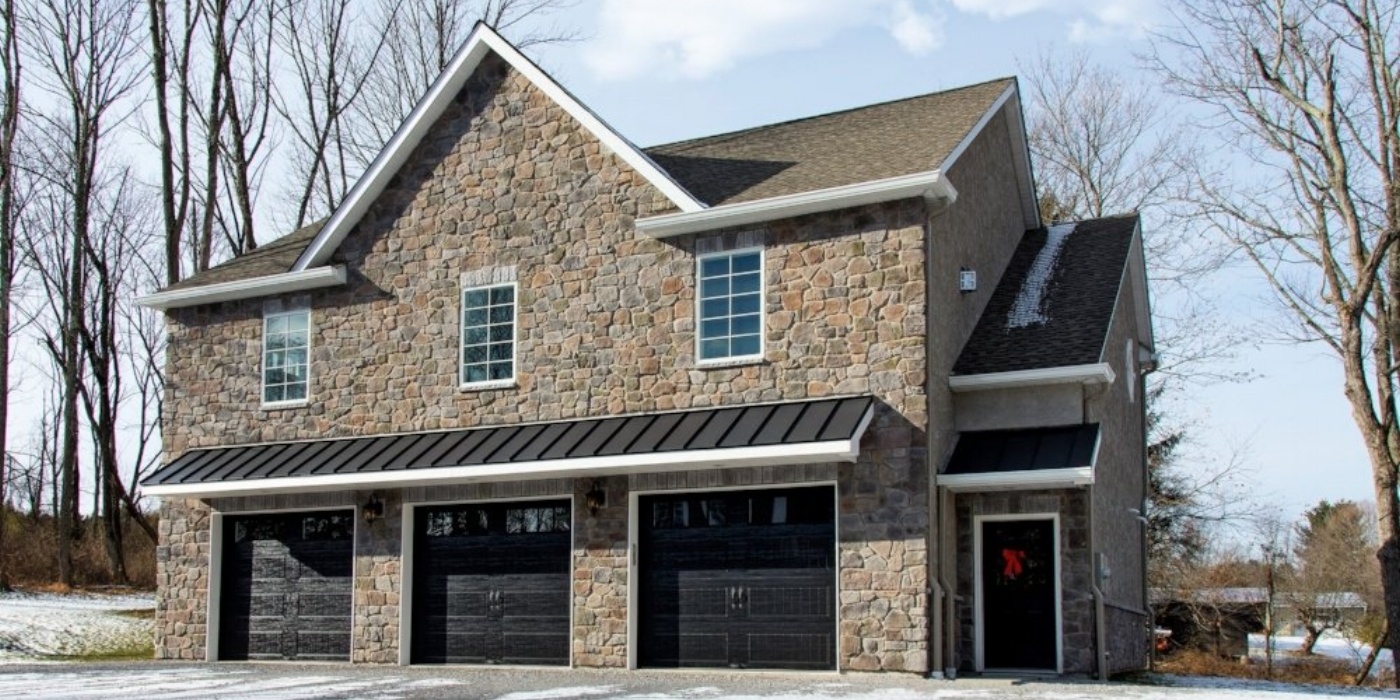 exterior of custom home with 3 car garage and stone by gtg builders in central new jersey