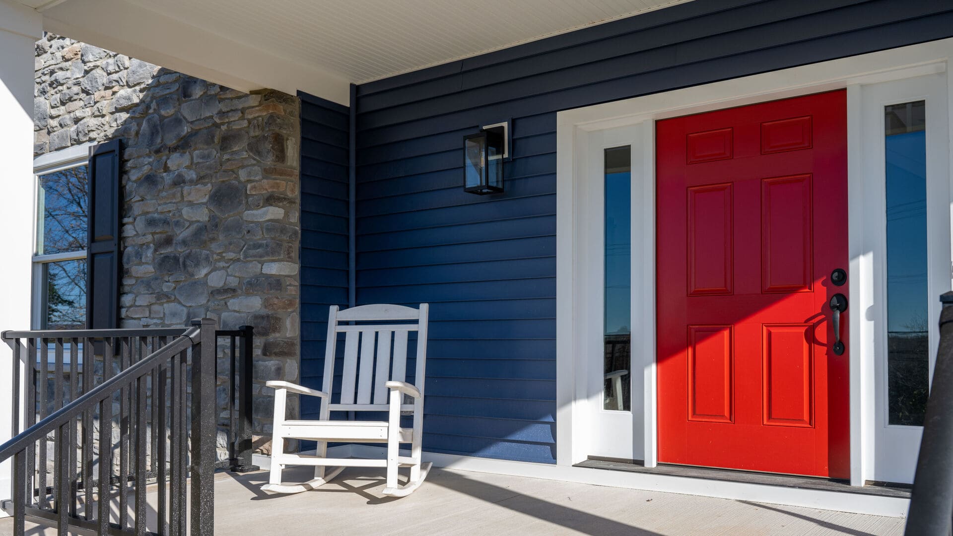 exterior of custom home with red door and blue paneling by gtg builders in central new jersey