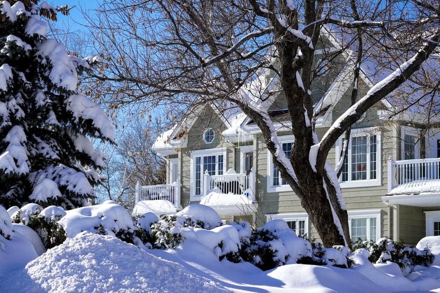 two story brown home surrounded by white snow - unsplash