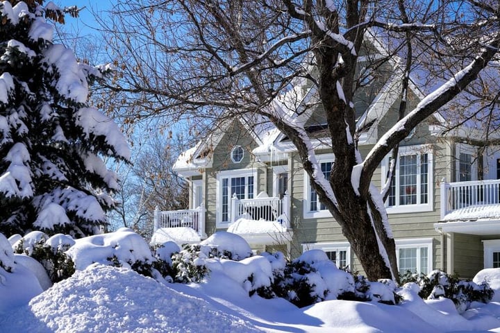 two story brown home surrounded by white snow - unsplash