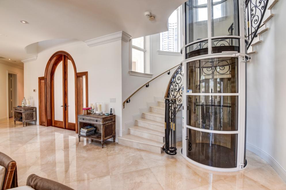 white residential elevator next to long spiral staircase - Residential Products Online