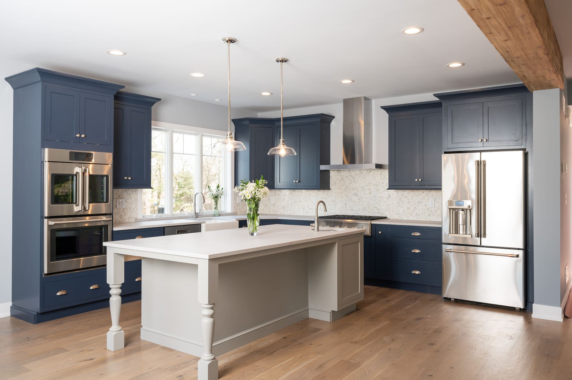 Grey-blue cabinetry in custom kitchen with white island