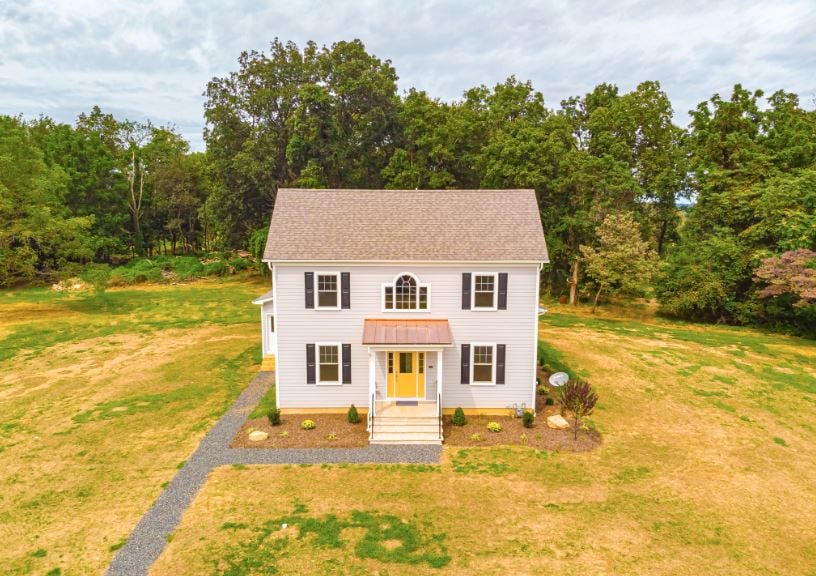 big house with yellow front door built on bought land in new jersey
