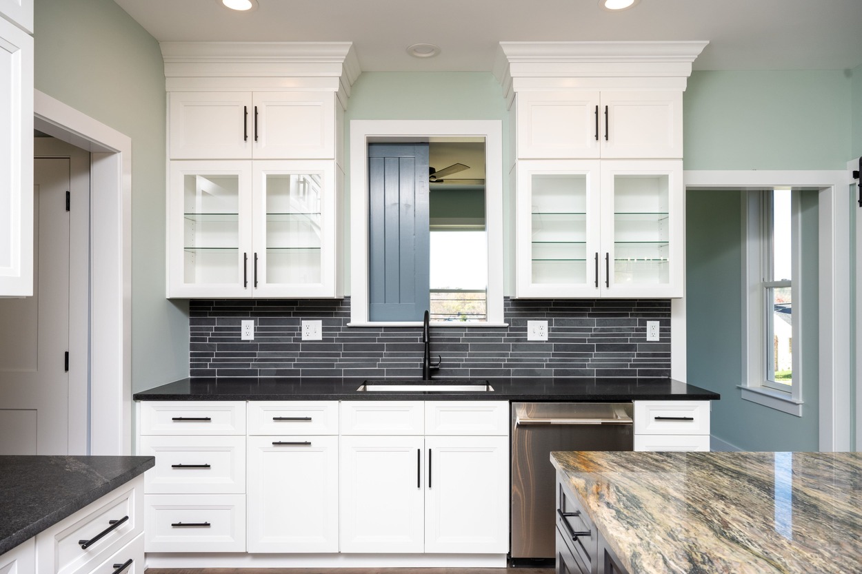 kitchen with white cabinets and dark tile backsplash by GTG Builders in Central New Jersey