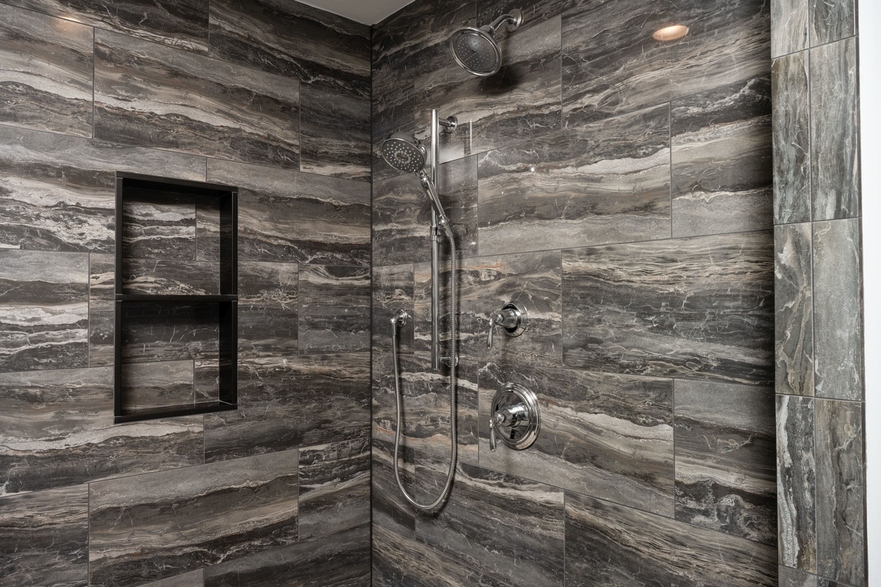 walk in shower with dark pattern wall in custom home by GTG Builders in Central New Jersey