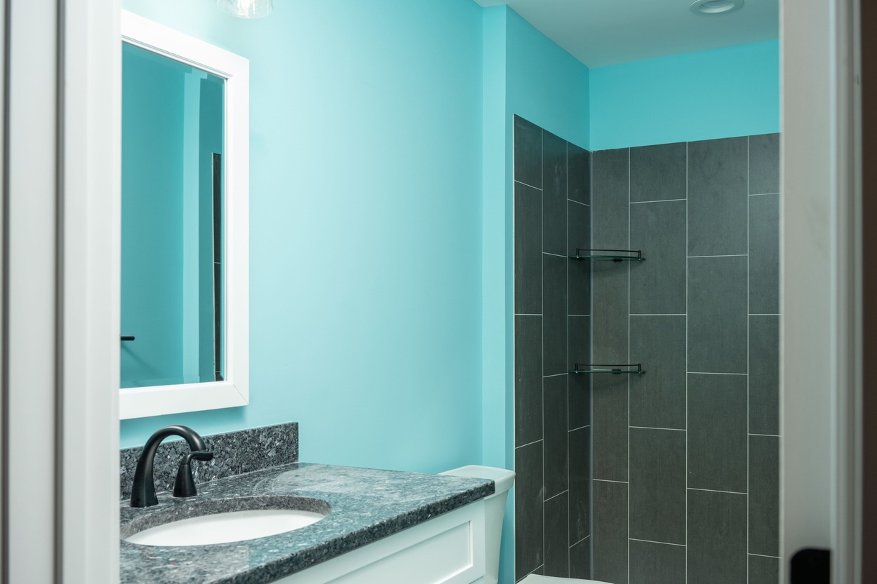 custom bathroom with blue walls and dark tiled shower in custom home by GTG Builders in Central New Jersey