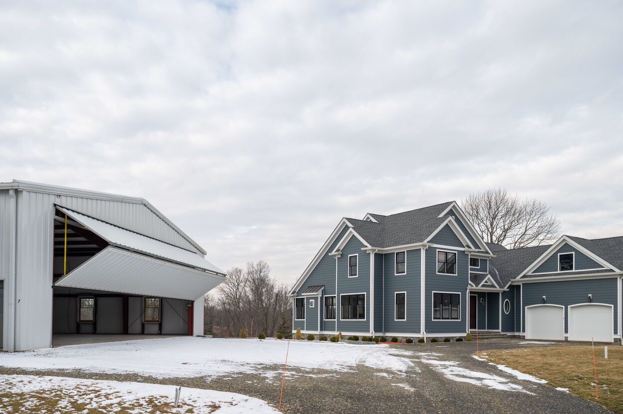 exterior blue home with hangar garage to the left by gtg builders in new jersey