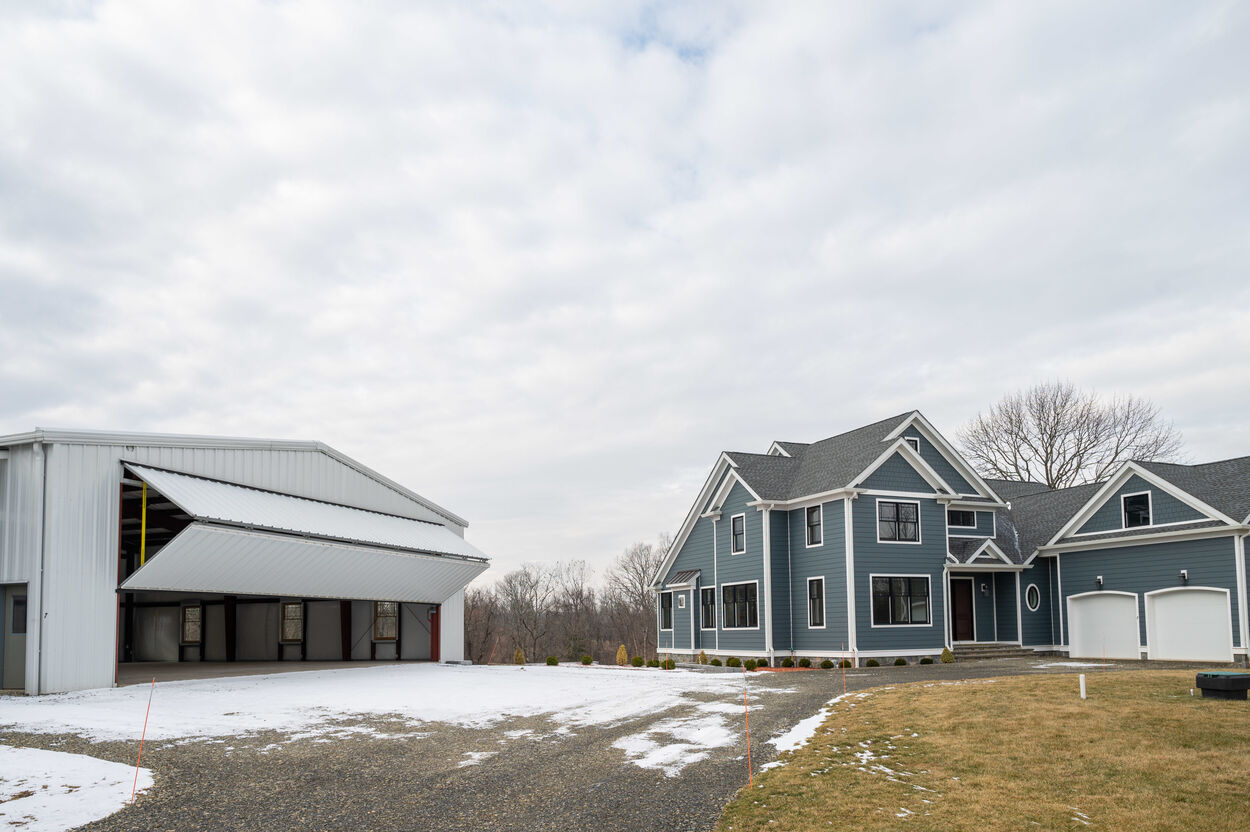 exterior blue home with hangar garage to the left by gtg builders in new jersey