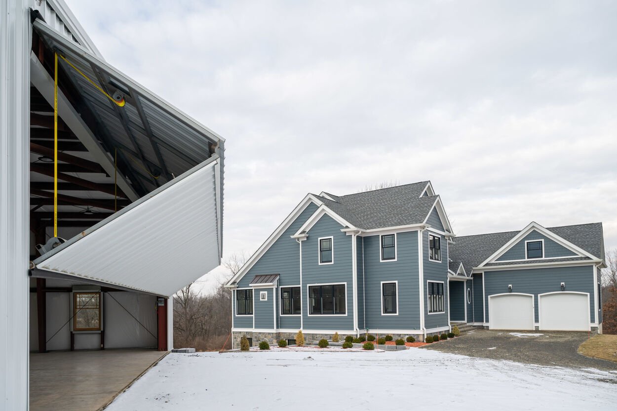 exterior blue home with hangar garage to the left by gtg builders in new jersey