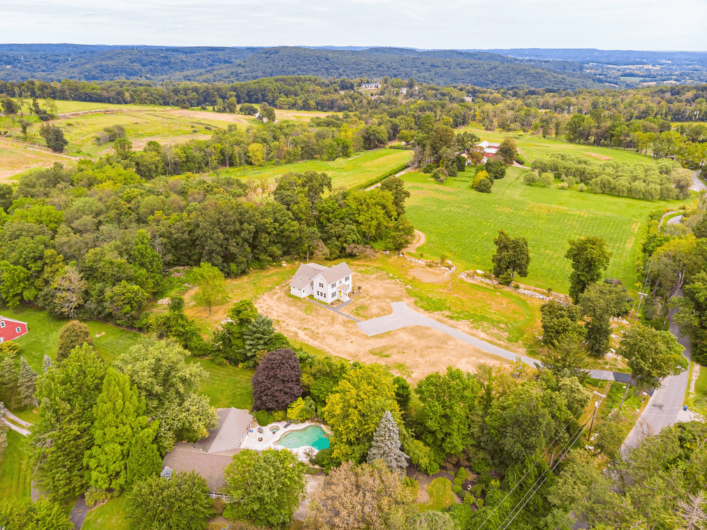 aerial shot of exterior of custom home with yellow door by gtg builders in central new jersey