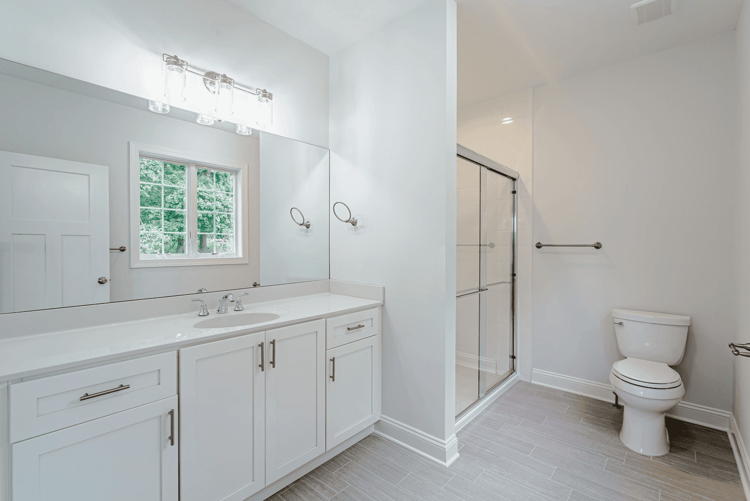 bathroom with walk in shower and white cabinets in custom home by gtg builders in central new jersey