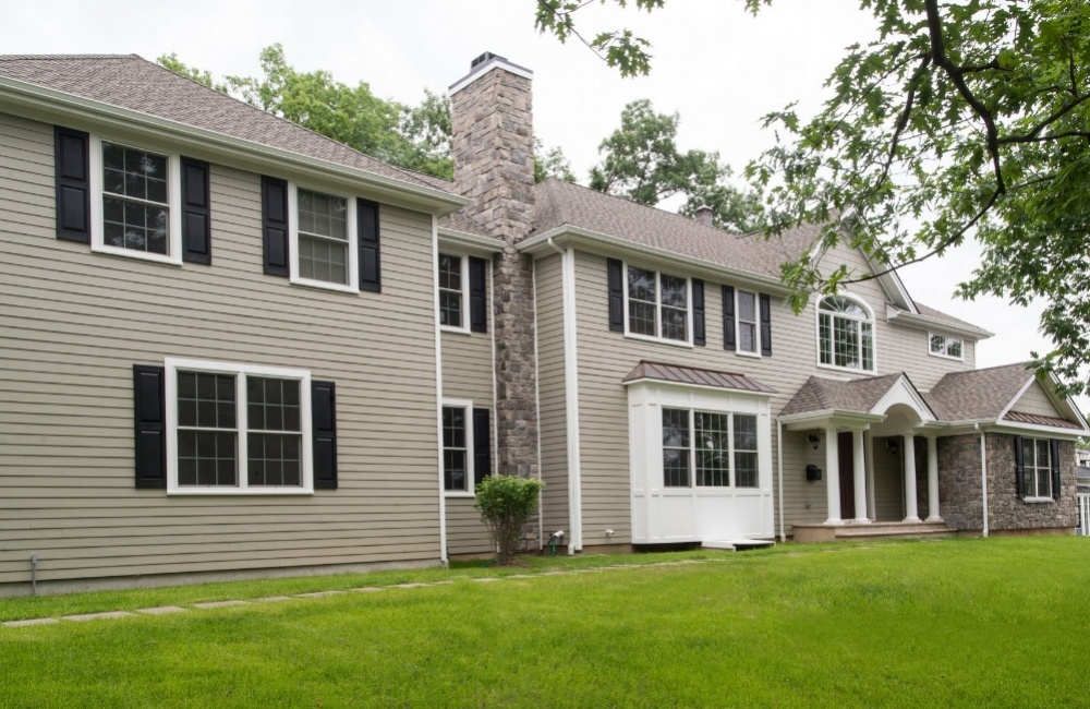 exterior of custom home with tan paneling and stone by gtg builders in central new jersey