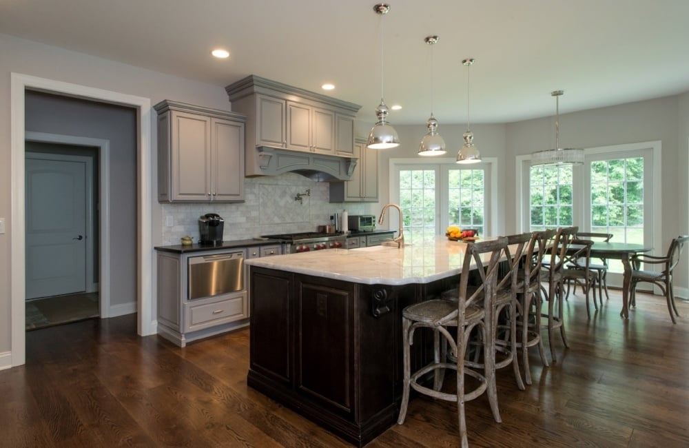 kitchen with white island, grey cabinets, and large refrigerator in custom home by gtg builders in central new jersey