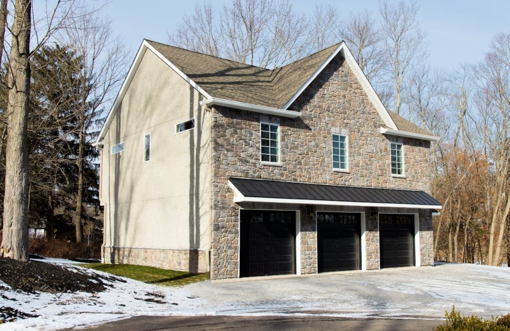 exterior of custom home with 3 car garage and stone by gtg builders in central new jersey