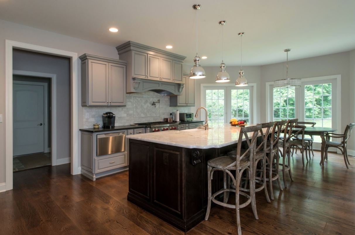 kitchen remodel with barstools at dark brown island and gray cabinets